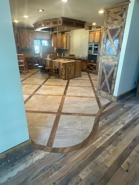 Modern kitchen with wood cabinets, elegant tile floor design, and open layout.