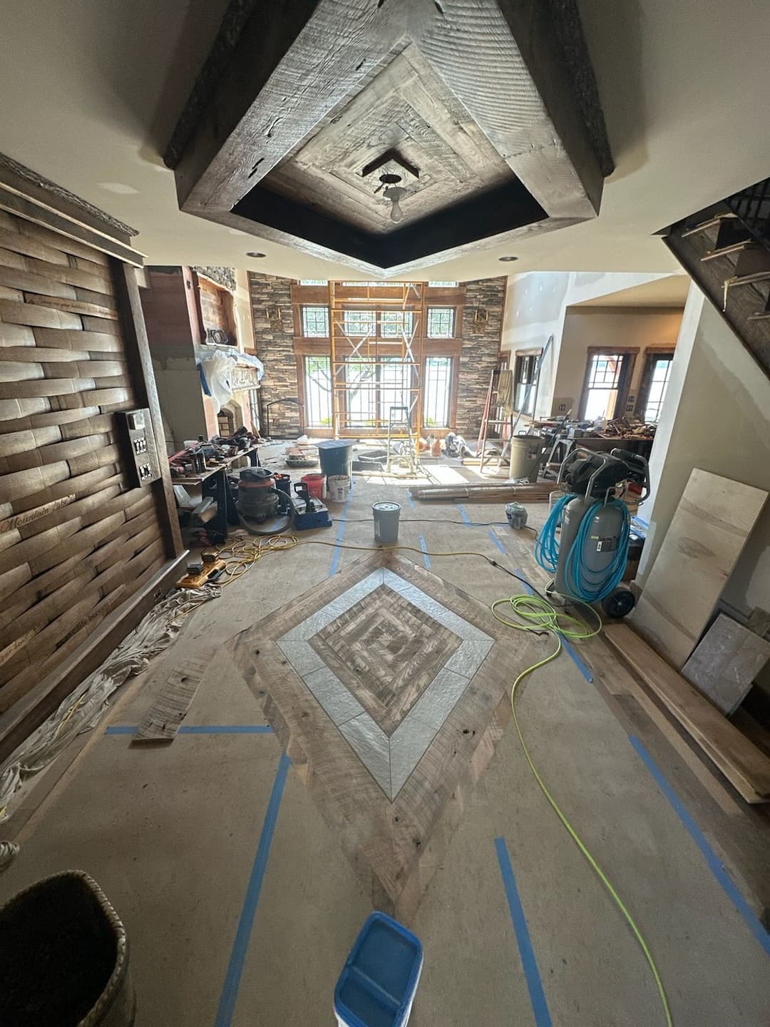 Renovation progress in a spacious living room with tools and construction materials visible.