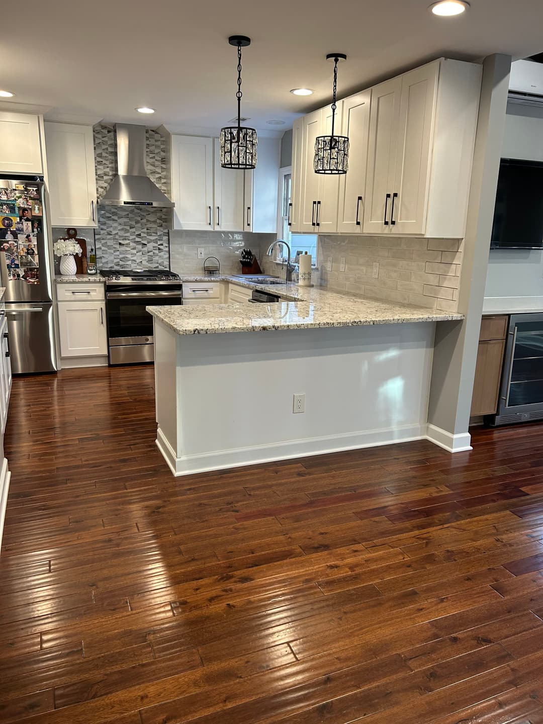 Modern kitchen with granite countertop, stainless steel appliances, and hardwood floors.