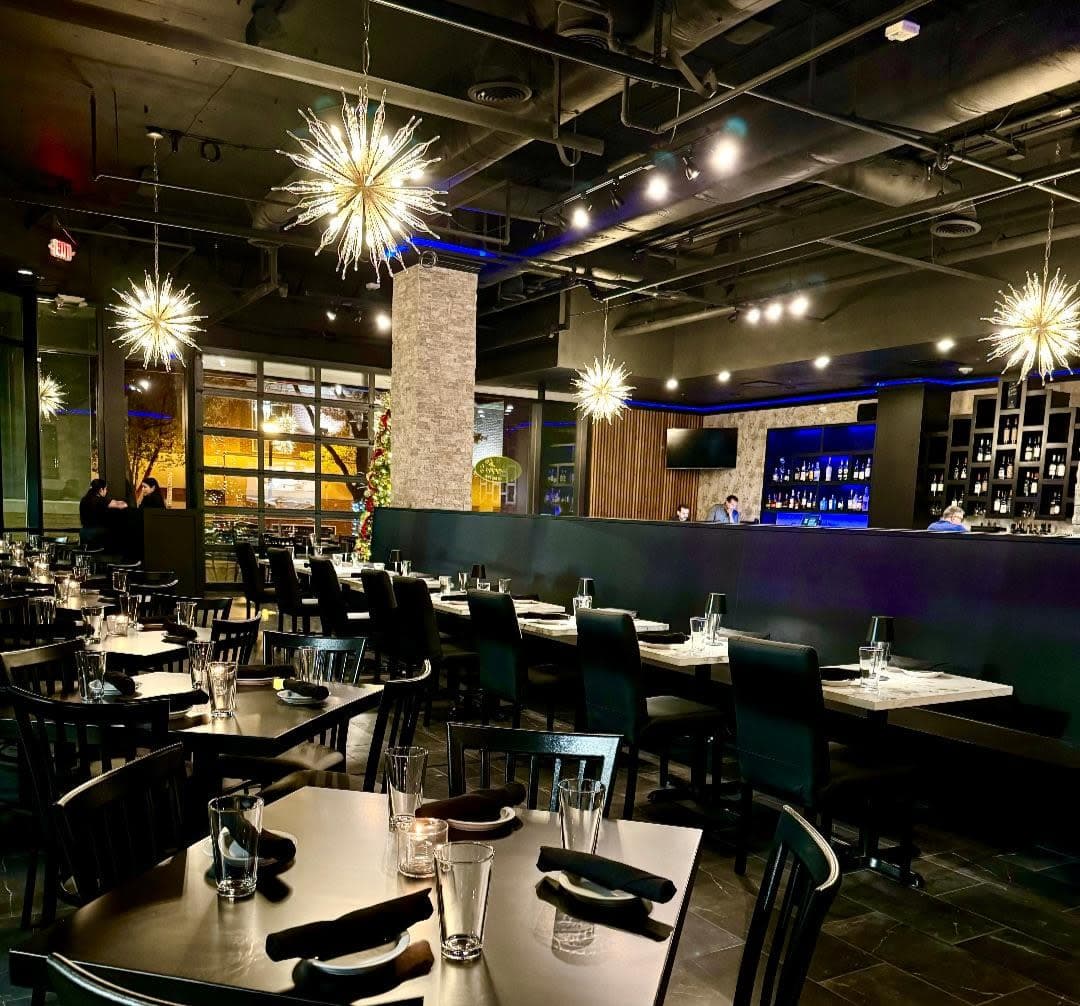 Modern restaurant interior with stylish lighting, elegant tables, and a vibrant atmosphere.